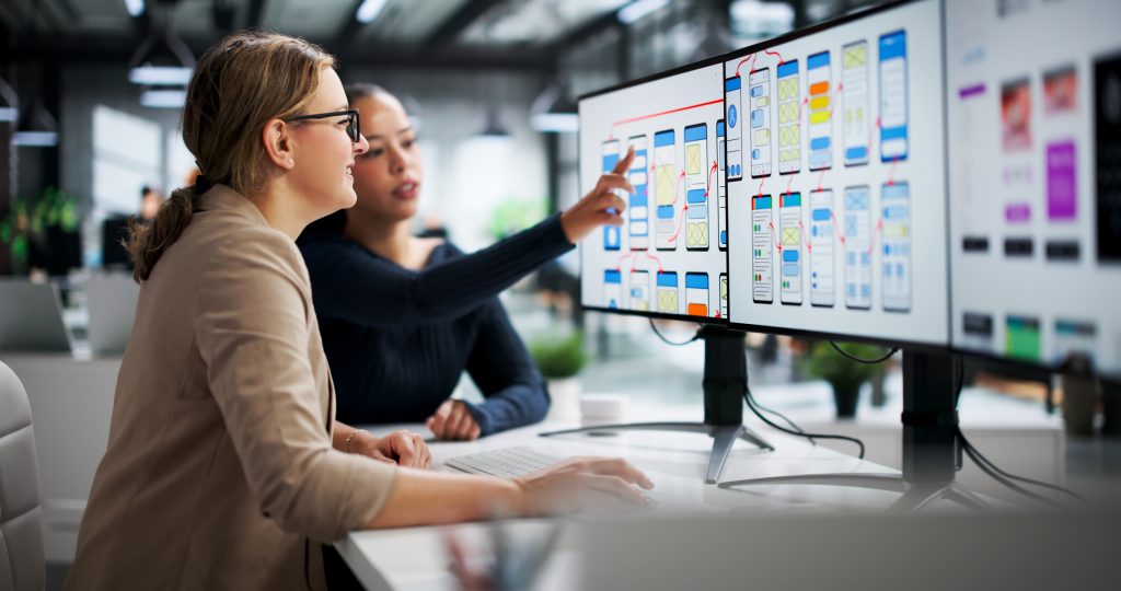 Kobiety pracujące nad user experience przy projekcie strony WWW.